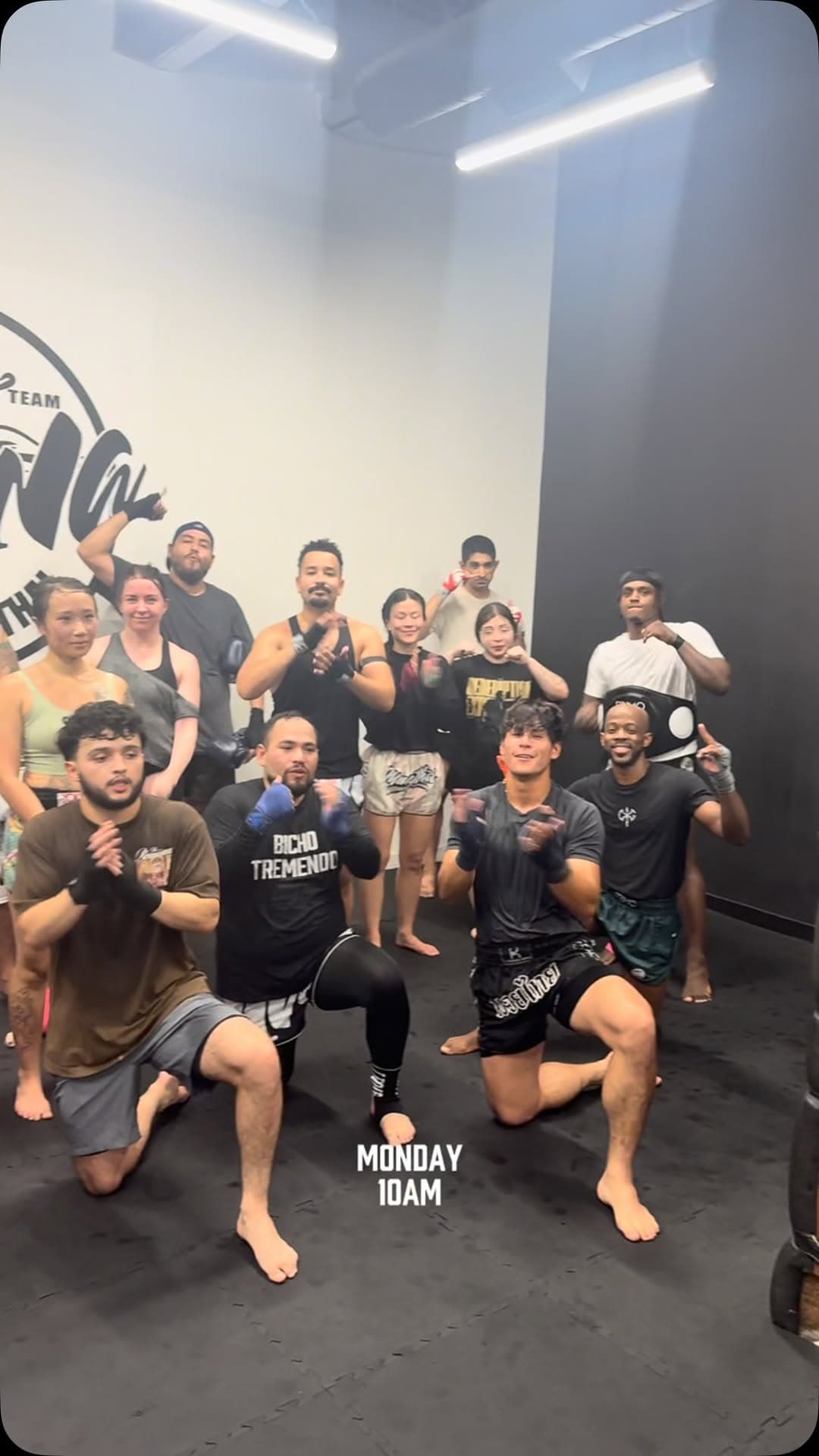 Large group of members kneeling together on the mats