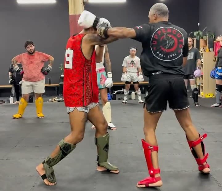 A member being coached through a slip drill on the mats at Team Mana Muay Thai