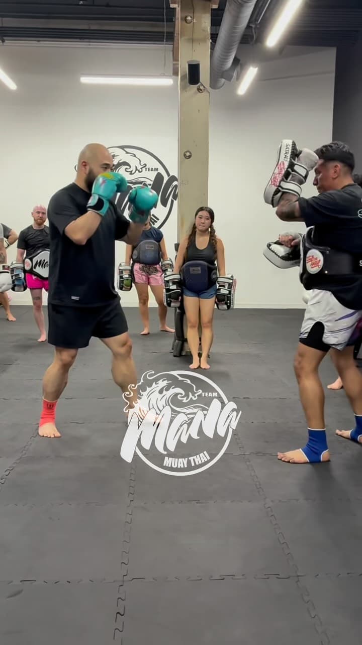 Adults pad drills class on the mats at Team Mana Muay Thai
