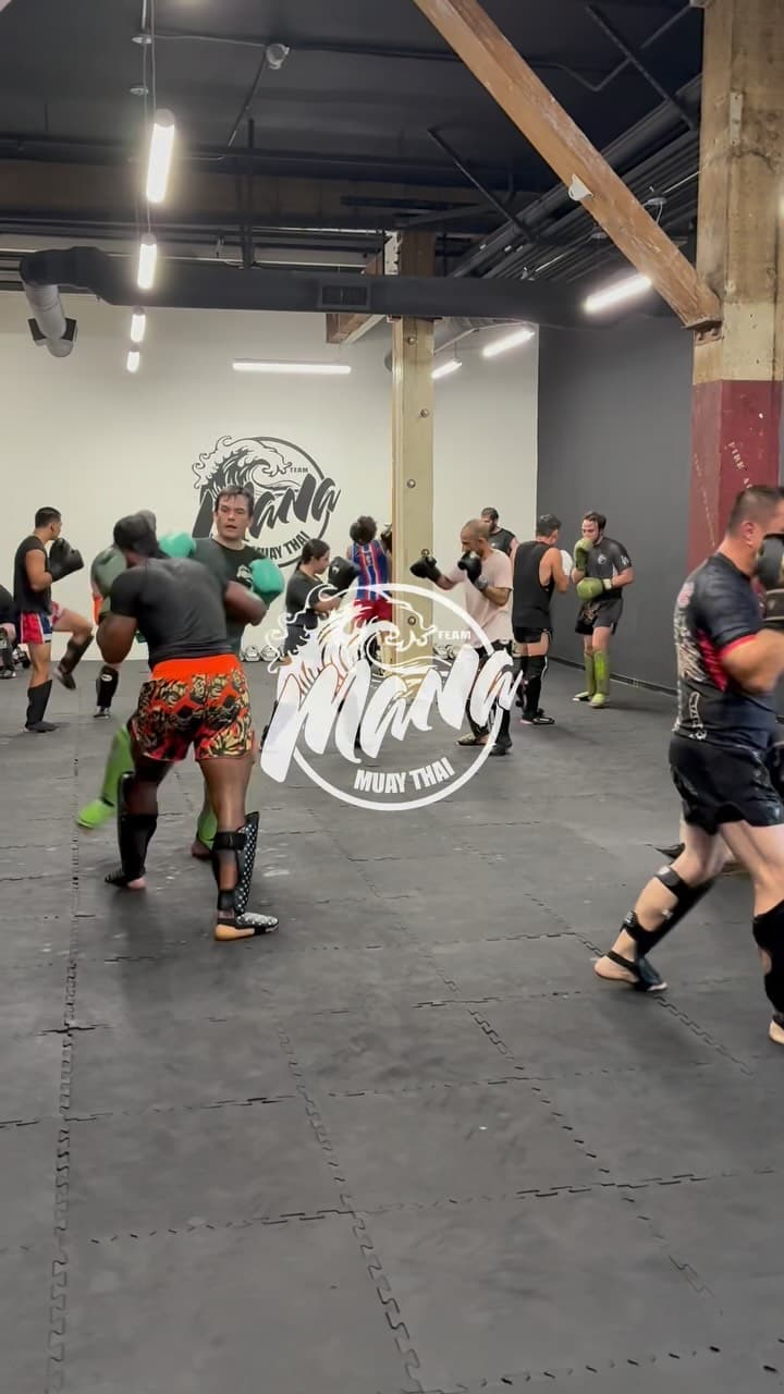 Sparring class in session, several pairs working with a coach watching